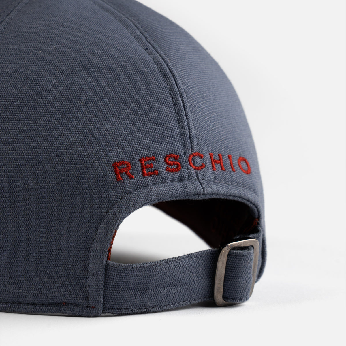 Navy blue cap with 'RESCHIO' embroidered on the back against a white background