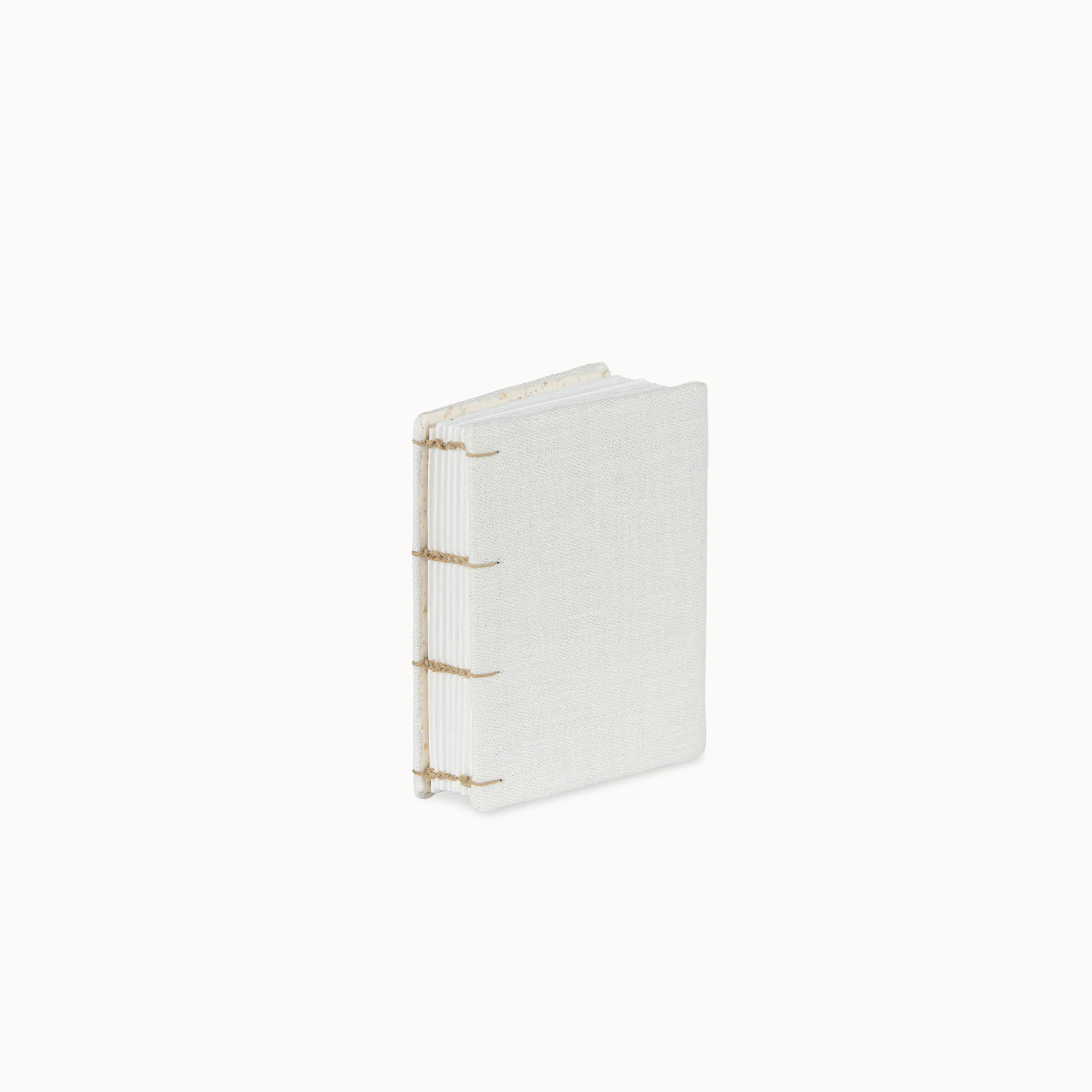 A small handmade book or journal with a white linen cover and gold wire binding, standing upright on a clean white background.