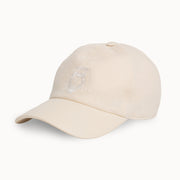 A light beige baseball cap with a subtle embroidered lion logo on the front, shown against a plain white background.