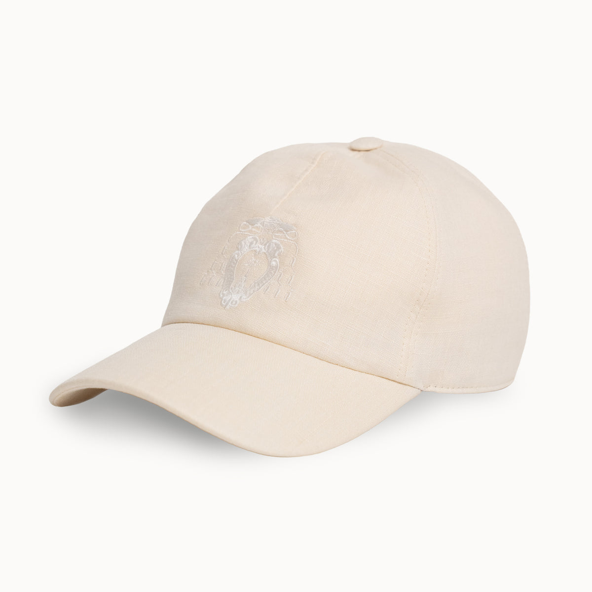 A light beige baseball cap with a subtle embroidered lion logo on the front, shown against a plain white background.